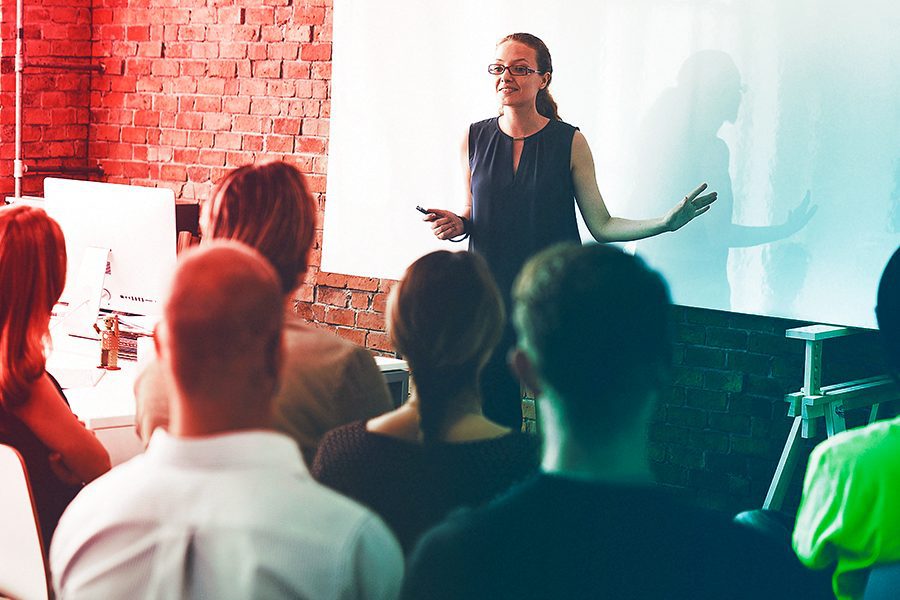 Mulher lecionando treinamento de novos colaboradores