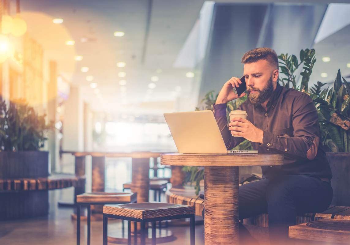 Homem realizando trabalho externo com um notebook