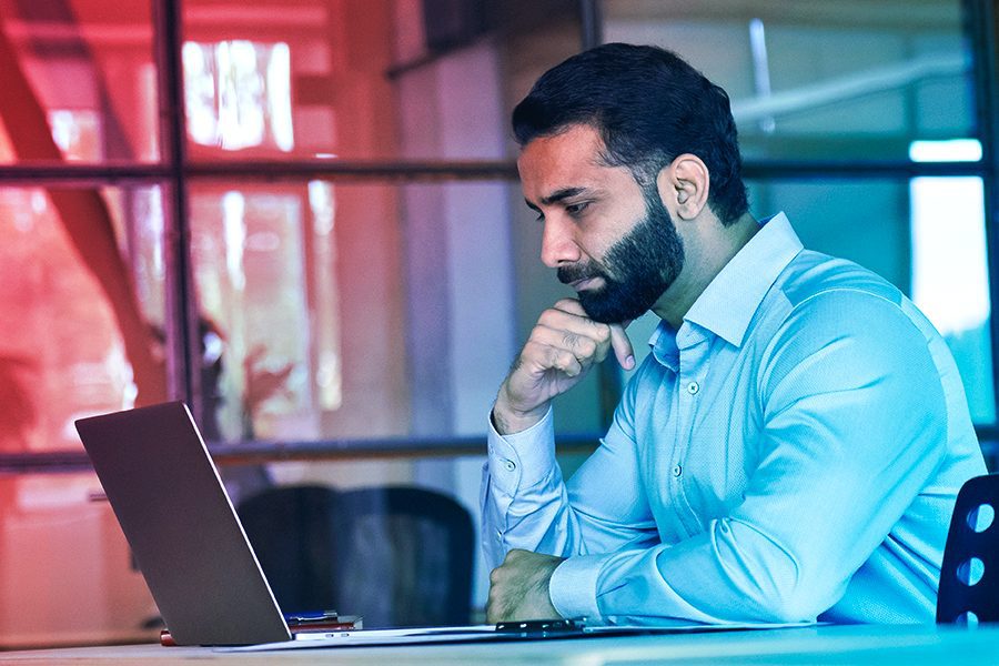 Homem olhando fixamente para um notebook