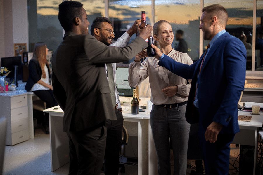 Grupo de pessoas celebrando com garrafas na empresa